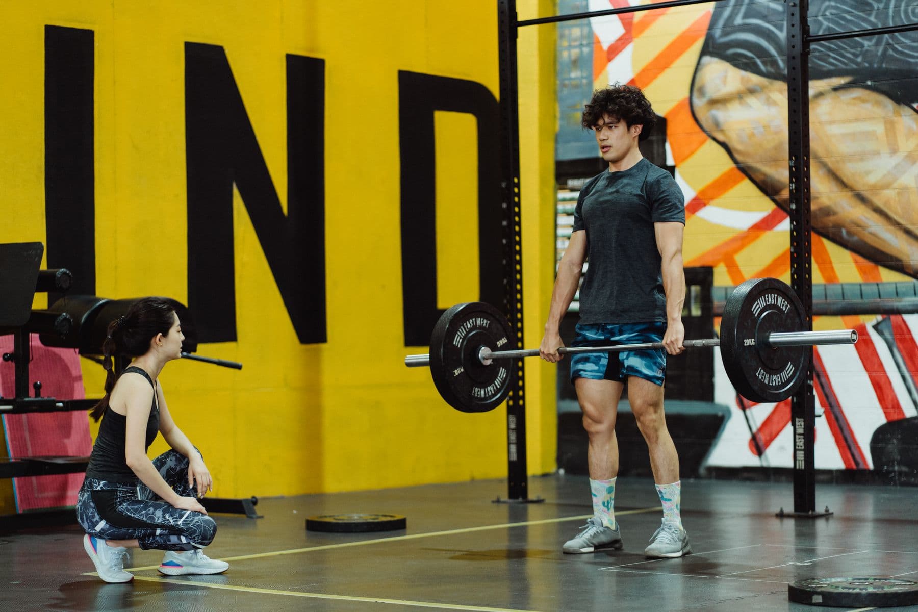 A coach watching closely as a client sets up a deadlift