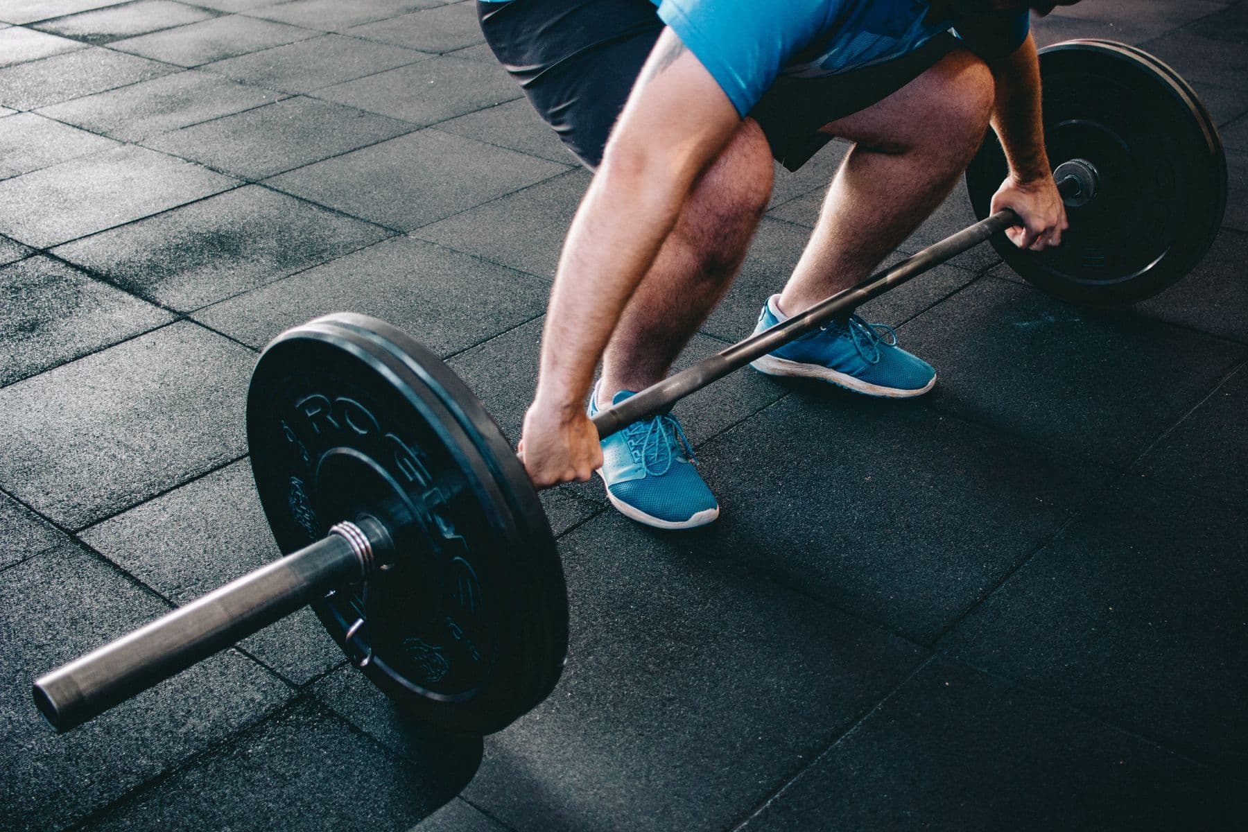 A lifter pulling a loaded barbell off the floor